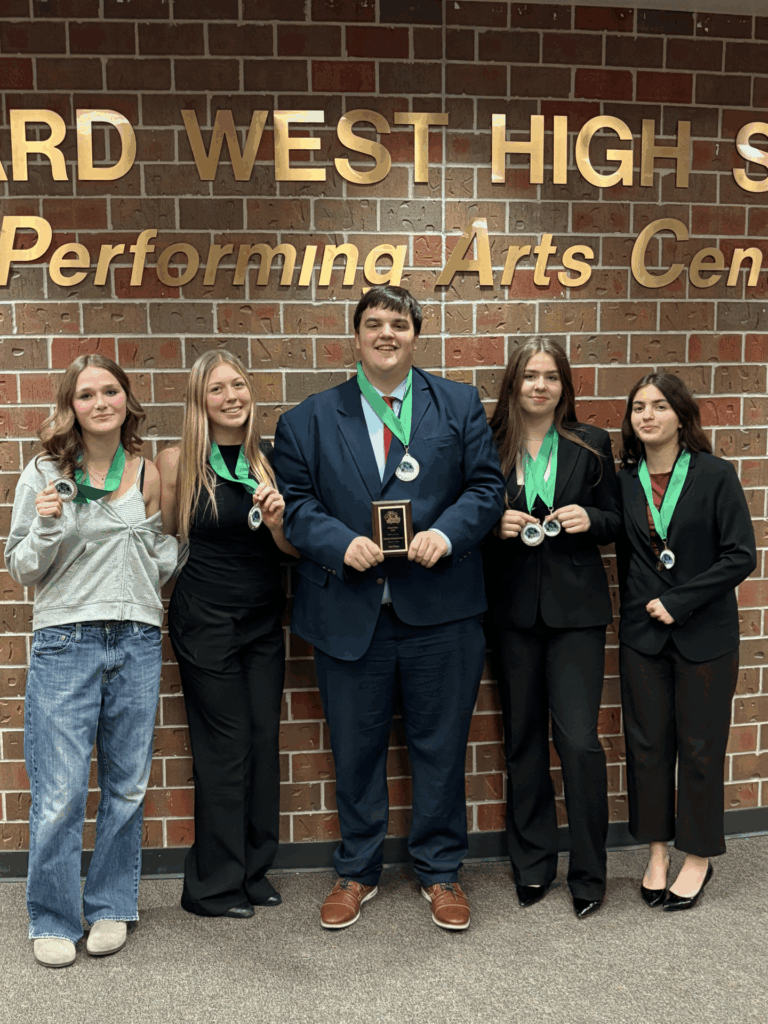 LSE Debate Students posting for a photo with their awards outside the Millard West auditorium